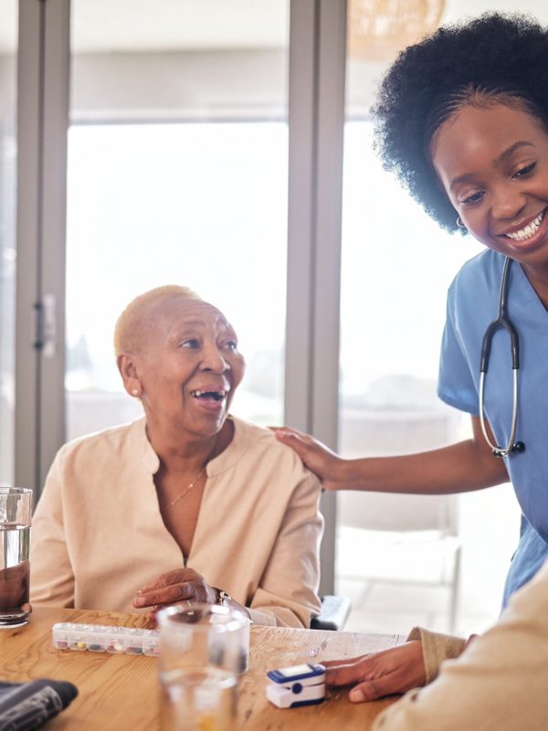 Doctor with senior women at table in nursing home for consultation, check up and conversation. Nurs.